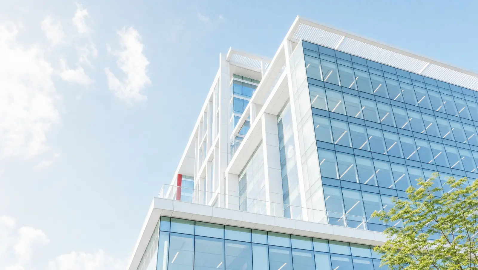 A modern glass office building in bright daylight